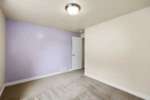 Carpeted spare room with baseboards and a textured ceiling