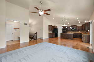Living room featuring ceiling fan, a chandelier, light wood-style floors, recessed lighting, and high vaulted ceiling