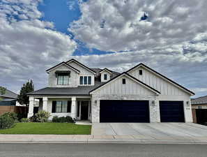 Modern inspired farmhouse featuring board and batten siding, an attached garage, and concrete driveway