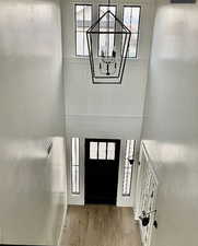 Entryway featuring wood finished floors and a chandelier