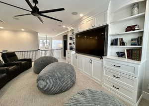 Living room featuring crown molding, a ceiling fan, light carpet, built in shelves, and recessed lighting