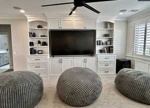 Living area featuring ceiling fan, crown molding, built in shelves, light carpet, and recessed lighting