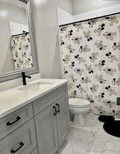Full bath featuring vanity, marble finish flooring, and a shower with shower curtain