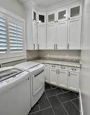 Laundry area with cabinet space, washer and clothes dryer, and dark tile patterned flooring