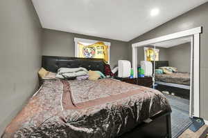 Carpeted bedroom featuring a closet and lofted ceiling