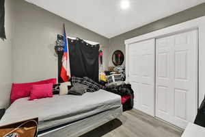 Bedroom with light wood-style flooring and a closet