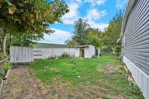 Fenced backyard featuring a storage unit