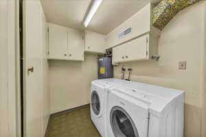 Washroom with cabinet space, washing machine and dryer, and water heater