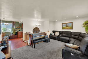 Carpeted living room with a chandelier and recessed lighting
