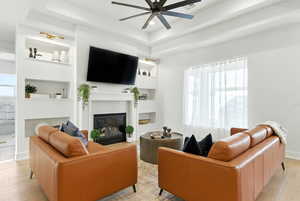 Living area featuring ceiling fan, built in features, a fireplace, light wood-style floors, and recessed lighting