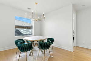 Dining area with light wood-type flooring and a chandelier
