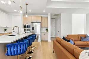 Kitchen with open floor plan, stainless steel appliances, recessed lighting, light wood-type flooring, and backsplash