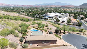 Aerial view of property and surrounding area featuring a mountainous background