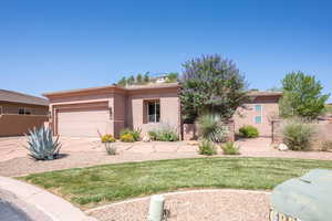 View of front of home with an attached garage, stucco siding, a front lawn, and concrete driveway