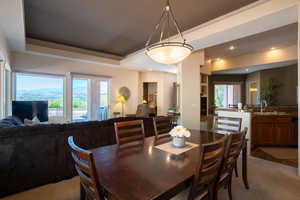 Dining space featuring a raised ceiling, recessed lighting, and carpet