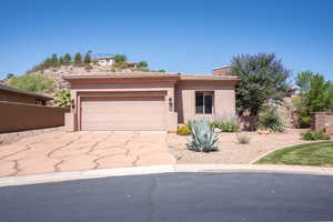 View of front of property featuring stucco siding, a garage, concrete driveway, a chimney, and a tiled roof