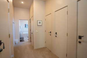 Corridor featuring light colored carpet and recessed lighting