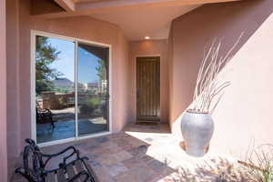 Doorway to property featuring stucco siding and a patio