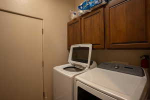Laundry area featuring washing machine and dryer and cabinet space