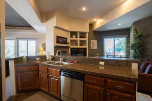 Kitchen featuring open floor plan, a peninsula, dishwasher, plenty of natural light, and recessed lighting