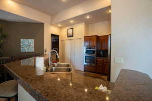 Kitchen with a breakfast bar, recessed lighting, stainless steel double oven, and tile countertops