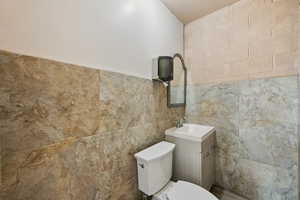 Bathroom featuring vanity and tile walls