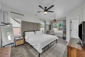 Carpeted bedroom featuring a ceiling fan