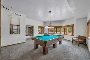 Game room featuring carpet floors, a textured ceiling, and billiards