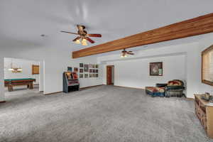 Carpeted living room featuring jukebox, ceiling fan, billiards table, and beam ceiling