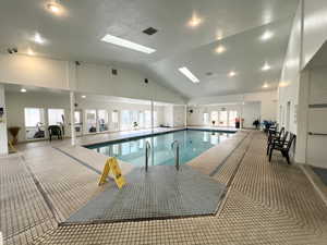 Indoor community pool featuring a skylight