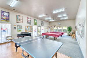 Game room with a textured ceiling, billiards table, plenty of natural light, light wood-type flooring, and a ceiling fan