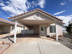 View of home's exterior with a tiled roof, stucco siding, an attached carport, and a patio area