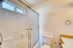 Full bathroom with bath / shower combo with glass door and vanity