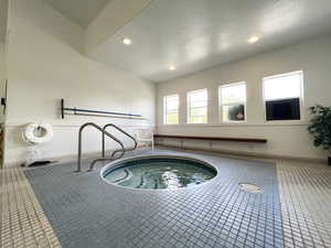 View of swimming pool featuring a hot tub and a sunroom