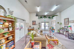 Carpeted living area featuring french doors