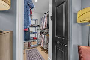 Walk in closet with upgraded lighting and floors.