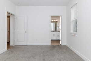 Unfurnished bedroom with carpet and ensuite bathroom