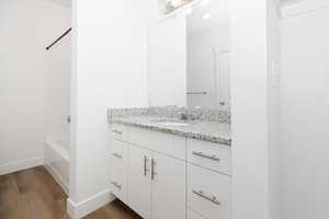 Bathroom featuring vanity, wood finished floors, and bathtub / shower combination
