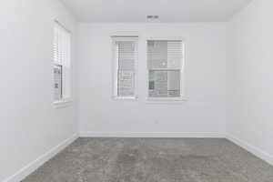 Carpeted empty room featuring baseboards