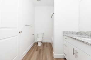 Bathroom featuring vanity, wood finished floors, and shower / bathtub combination