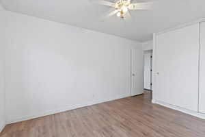 Spare room with wood finished floors and a ceiling fan