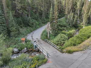Aerial view of property and surrounding area with a forest
