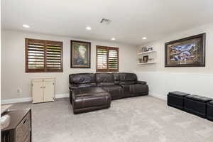 Carpeted living room featuring wainscoting and recessed lighting