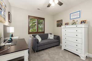Home office featuring light colored carpet and a ceiling fan