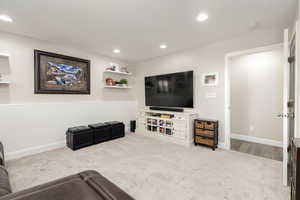 Living room featuring carpet floors, recessed lighting, and a wainscoted wall