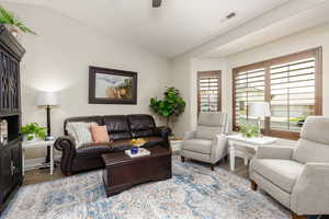 Living room with vaulted ceiling, wood finished floors, and ceiling fan