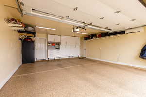 Garage with freestanding refrigerator and a wall mounted AC