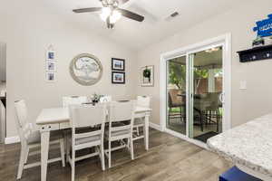 Dining space featuring wood finished floors, lofted ceiling, and a ceiling fan