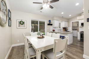 Dining room with wood finished floors, ceiling fan, washer / dryer, and recessed lighting