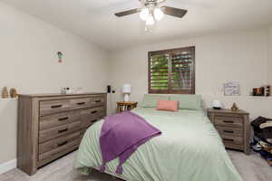 Bedroom with light colored carpet and a ceiling fan